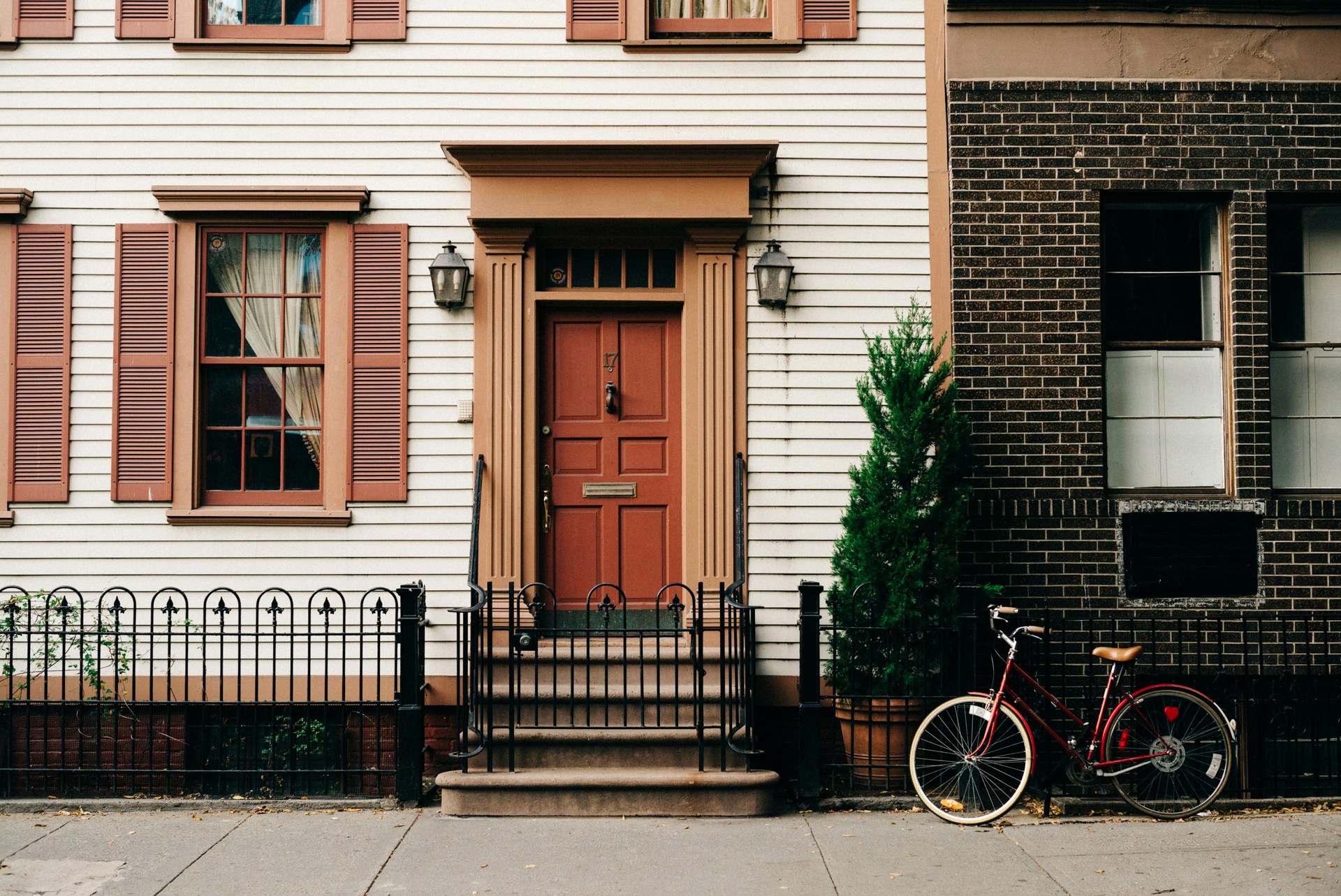 A row house entrance with a red door, warm and welcoming